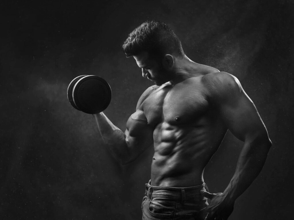 Hombre musculoso sin camisa levantando pesas en el gimnasio, entrenamientos fitness para ganar musculo y entrenamiento fitness para perder grasa